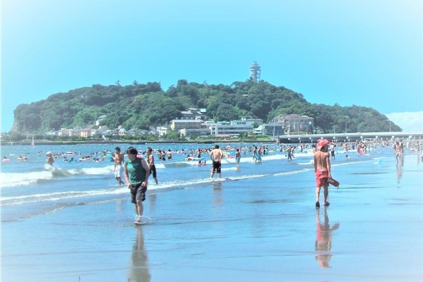 江の島の見える海岸で海遊びをしている人々