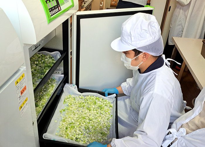 協力農家から寄せられた未利用野菜（大きさが不揃いなどで市場へ出せないもの）の処理をし、乾燥できるように刻む作業の様子。市内の福祉事業所の通所メンバーが定期的にラボに訪れ、作業に取り組んでいる。メンバーがそれぞれできる作業に合わせ、分担して加工。一つひとつの作業がとても丁寧で、集中して行っている。